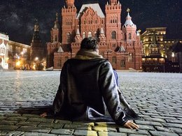 Человек сидит на брусчатке, на Красной площади