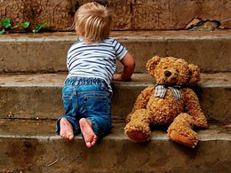 Ребенок играет с медведем