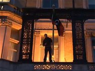 Один из протестующих сменил флаг в посольстве Ливиив Лондоне. Кадр: BBC
