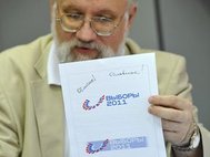 Владимир Чуров демонстрирует логотип предстоящих выборов.