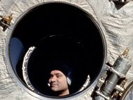 Космонавт Поляков наблюдает через иллюминатор станции «Мир» шаттл «Дискавери»
