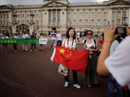 Китайские туристы позируют на фоне Букингемского дворца