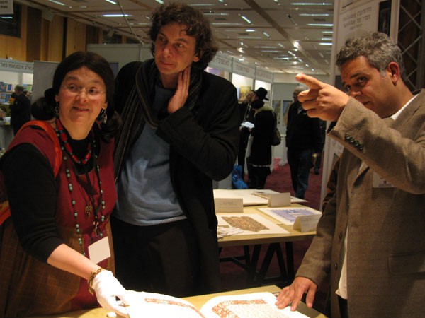 Андрей Бондаренко (в центре) на книжной ярмарке изучает работу коллег