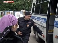 Сестру пойманного за изнасилование 18-летнего Магомеда Магомедова сажают в полицейскую машину