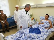 Министр обороны Сергей Шойгу и десантники, пострадавших при обрушении казармы в Омске.