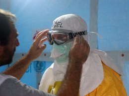 Сотрудник организации "Врачи без границ" готовится войти в палату к больным лихорадкой Эбола