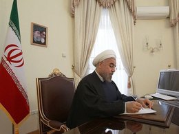 Президент Ирана Хасан Рухани подписывает документ