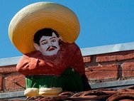 Фигура мексиканца в сомбреро на крыше дома