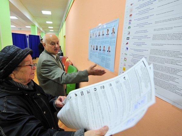 Избиратели перед информационным стендом. Москва, 18 сентября 2016 года