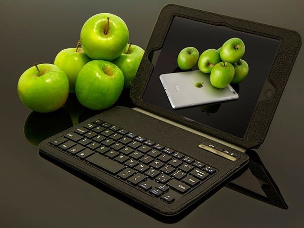 Яблоки на столе с планшетом