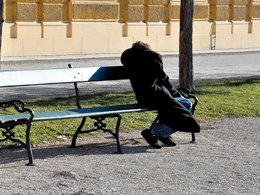 Бездомный человек на скамейке