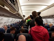 Пассажиры размещают багаж в самолете