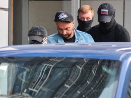 К. Серебренников выходит из Следственного комитета в сопровождении охраны