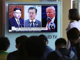 Ким Чен Ын, Мун Чжэ Ин и Дональд Трамп на экране телевизора