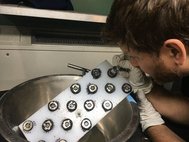 Марк Фриз ищет на магнитной доске железные частицы метеорита