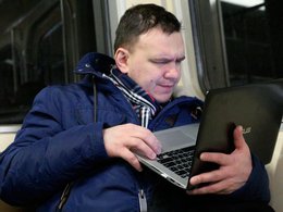 Мужчина в метро с ноутбуком