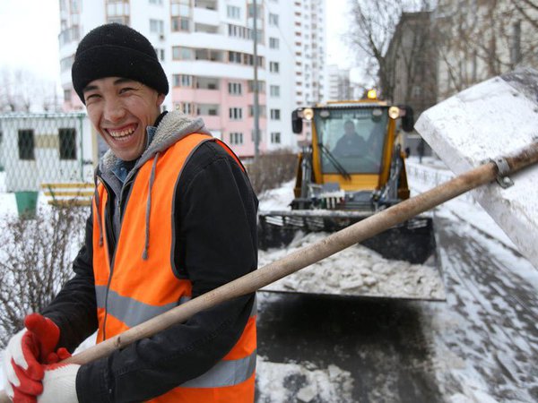 Иностранный рабочий убирает снег