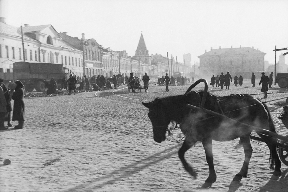 Своей серией снимков, сделанных в октябре 1942 года, фотограф явно пытался запечатлеть повседневную жизнь в российском городе. На заднем плане советские военнопленные ремонтируют улицу, за ними виден старый город